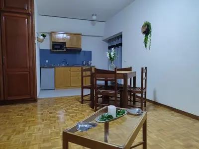 a living room with a table and chairs and a kitchen at Residencial P&P in Mindelo