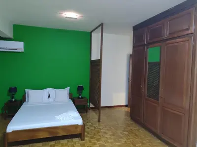 a green room with a bed and a green wall at Residencial P&P in Mindelo