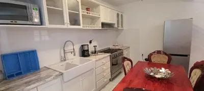 a kitchen with white cabinets and a table and a sink at Casa Azul in Paul