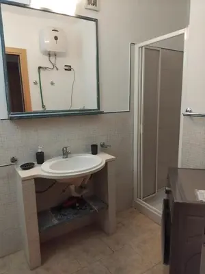a bathroom with a sink and a mirror and a shower at Moradias No Stress in Santa Maria