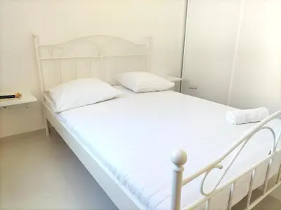 a white bed with white sheets and pillows at Cozyapartment Povoacao, Rbra GrandeSanto Antao in Ribeira Grande