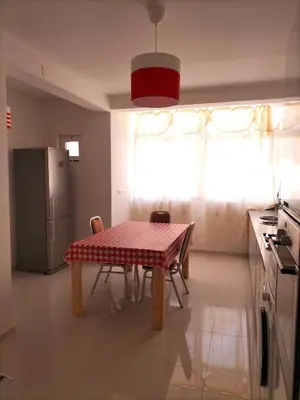 a kitchen with a table and chairs and a refrigerator at Cozyapartment Povoacao, Rbra GrandeSanto Antao in Ribeira Grande