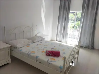 a white bedroom with a bed with a flower pattern at Cozyapartment Povoacao, Rbra GrandeSanto Antao in Ribeira Grande