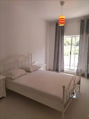 a bedroom with a white bed and a window at Cozyapartment Povoacao, Rbra GrandeSanto Antao in Ribeira Grande