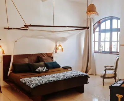 a bedroom with a bed with a canopy at Casa Cesaria Guest House in Sal Rei
