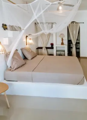 a bedroom with a white bed with a ceiling at Casa Cesaria Guest House in Sal Rei