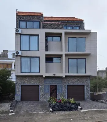 a house with four garage doors in front of it at Ocean View Studio 1 in Mindelo