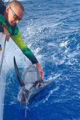 a man holding a shark in the water at Ocean View Studio 1 in Mindelo