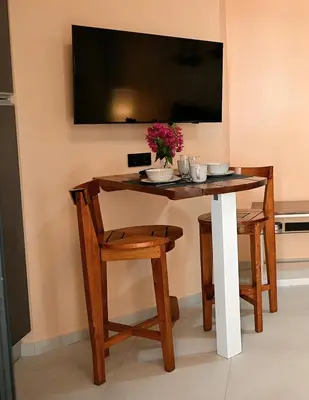 a table with two chairs and a television on a wall at Nature Breeze in Sal Rei