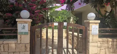 a wooden gate in front of a house with flowers at Nature Breeze in Sal Rei