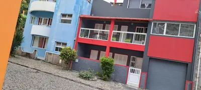 an apartment building with red and blue paint at Casa Flor Apartment in Ribeira Grande