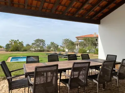 a wooden table and chairs on a patio at Casa de Cabo Verde in Santa Maria