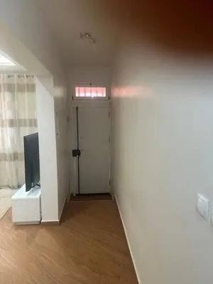 an empty room with a door and a television at Morabeza Lodge in Mindelo