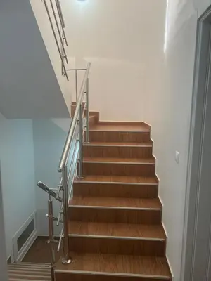 a staircase with a metal handrail and wooden steps at Morabeza Lodge in Mindelo