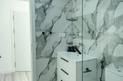 a bathroom with a marble wall at Edifício Yes, Luxury 2 Bed Apartments, Praia, Cape Verde with Balcony and AC in Praia