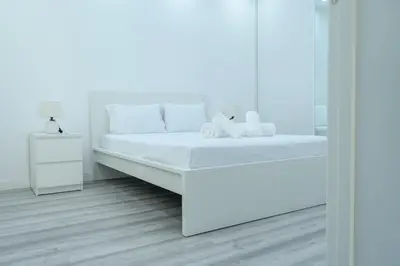 a white bedroom with a white bed and a mirror at Edifício Yes, Luxury 2 Bed Apartments, Praia, Cape Verde with Balcony and AC in Praia