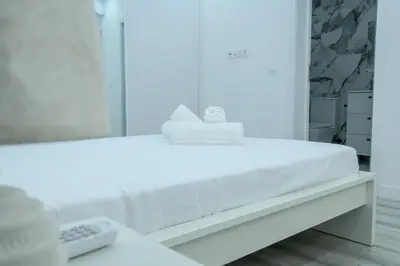 a white bed in a room with a mirror at Edifício Yes, Luxury 2 Bed Apartments, Praia, Cape Verde with Balcony and AC in Praia