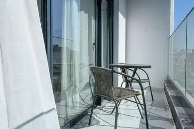 a balcony with two chairs and a table at Edifício Yes, Luxury 2 Bed Apartments, Praia, Cape Verde with Balcony and AC in Praia