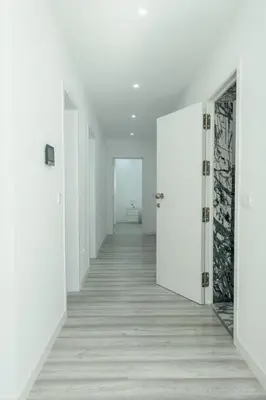 an empty hallway with white walls and white doors at Edifício Yes, Luxury 2 Bed Apartments, Praia, Cape Verde with Balcony and AC in Praia