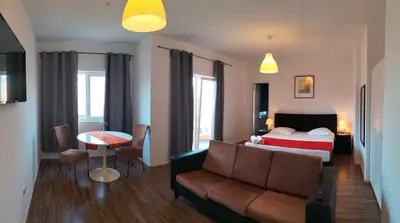 a hotel room with a bed and a couch and a table at Hotel Miranda & Miranda in Ponta do Sol