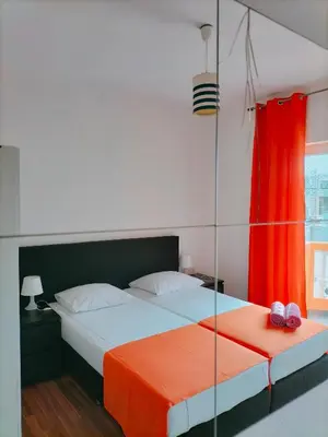 a bedroom with two beds and a red curtain at Hotel Miranda & Miranda in Ponta do Sol