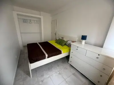 a small bedroom with a bed and a dresser at Single & double Room for women only & Breakfast in Praia
