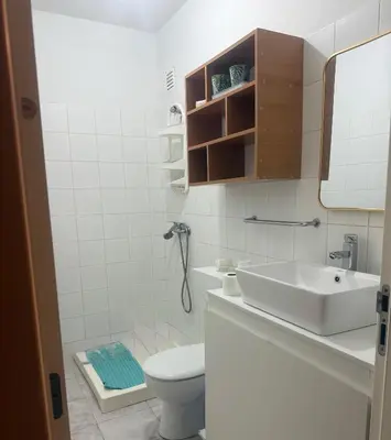 a bathroom with a sink and a toilet and a mirror at Single & double Room for women only & Breakfast in Praia