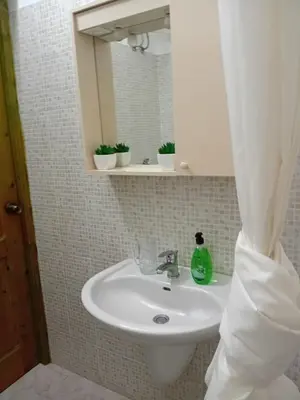 a bathroom sink with a mirror and a soap bottle on it at Sal Rei Apartments, Boa Vista in Sal Rei