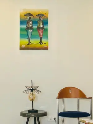 two chairs and a painting of two women with umbrellas at Sal Little Heart Sun NEW Apartment 5 in Santa Maria