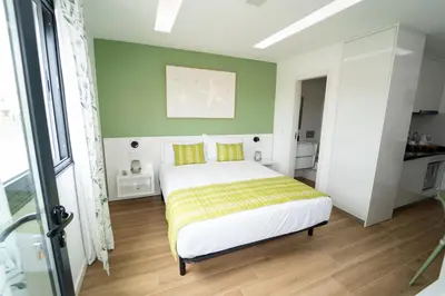 a bedroom with a bed and a green wall at GREEN STUDIO TARRAFAL - Ap 02 in Prainha