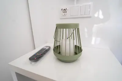 a green vase sitting on a table next to a remote control at GREEN STUDIO TARRAFAL - Ap 02 in Prainha