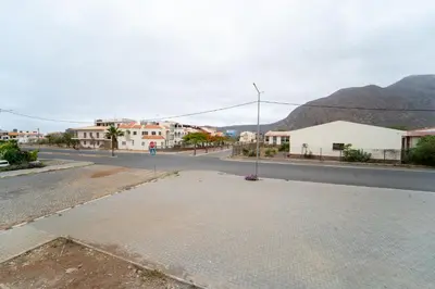 an empty street in a town with mountains in the background at GREEN STUDIO TARRAFAL - Ap 02 in Prainha
