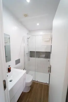 a white bathroom with a toilet and a shower at GREEN STUDIO TARRAFAL - Ap 01 in Prainha