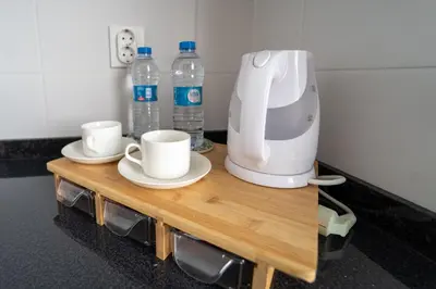 a coffee maker and two cups on a table with water bottles at GREEN STUDIO TARRAFAL - Ap 01 in Prainha