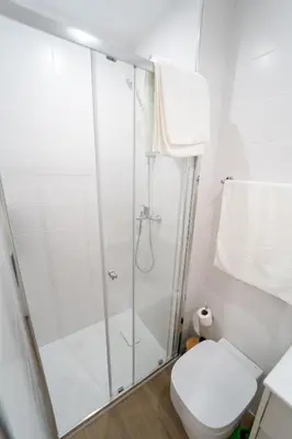 a white bathroom with a shower and a toilet at GREEN STUDIO TARRAFAL - Ap 01 in Prainha
