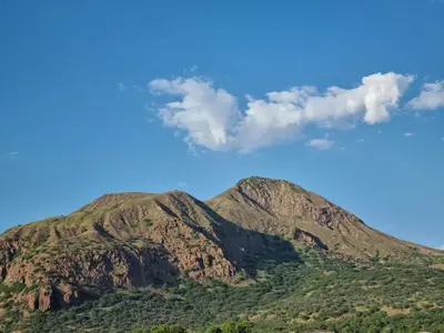 a mountain with green trees and a blue sky at GREEN STUDIO TARRAFAL - Ap 01 in Prainha