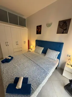 a bedroom with a blue bed with two towels on it at Holiday Properties Ocean Breeze in Santa Maria
