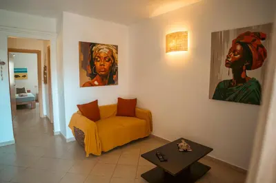 a living room with a yellow couch and paintings on the wall at Orange by No Stress ACWifi in Santa Maria