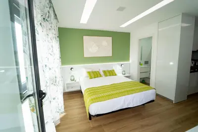a bedroom with a bed and a green wall at GREEN STUDIO TARRAFAL - Ap 03 in Tarrafal