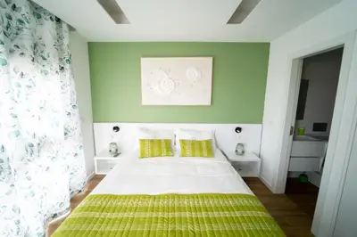 a bedroom with green walls and a bed with yellow pillows at GREEN STUDIO TARRAFAL - Ap 03 in Tarrafal