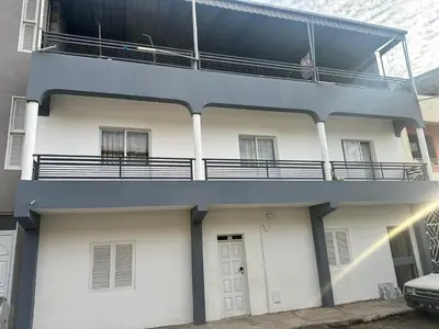 a man sitting on the balcony of a building at Kasa Kutxa in Tarrafal