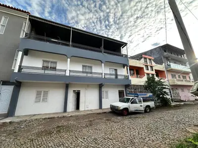 a white house with a truck parked in front of it at Kasa Kutxa in Tarrafal