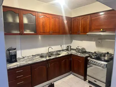 a kitchen with wooden cabinets and a sink and a stove at Kasa Kutxa in Tarrafal