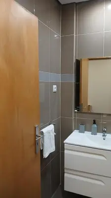 a bathroom with a sink and a door with a mirror at Clara's Place - Faia Suite in Praia