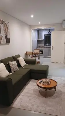 a living room with a green couch and a table at Clara's Place - Morabeza Suite in Praia