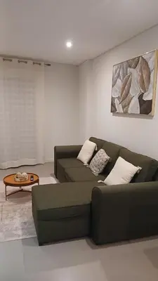 a living room with a green couch and a table at Clara's Place - Morabeza Suite in Praia