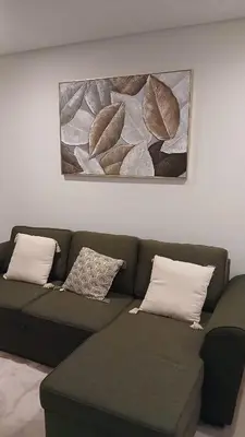 a green couch with pillows and a painting on the wall at Clara's Place - Morabeza Suite in Praia