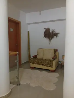 a living room with a couch and a palm tree on the wall at Four Palms Guest House in Praia