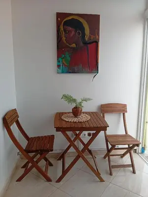 a table and two chairs and a painting on the wall at Four Palms Guest House in Praia