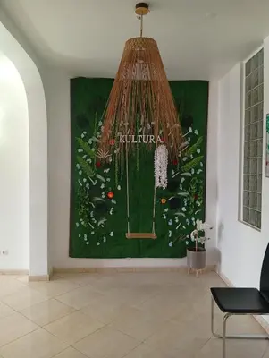 a large painting on a wall in a living room with a chandelier at Four Palms Guest House in Praia